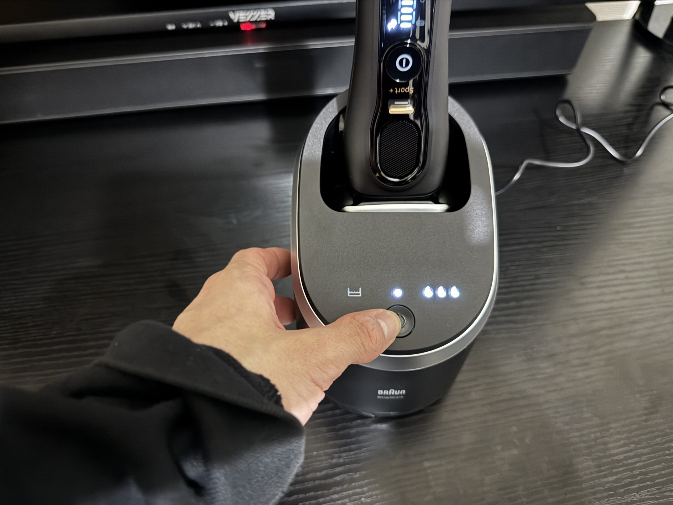 洗浄機にシェーバーをセットした写真。インジケーターが点灯しています。